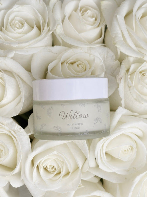Jar of cream labeled 'Willow' surrounded by white roses