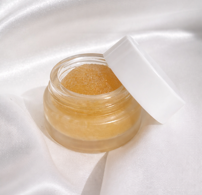 Jar of gold cream on a white satin background